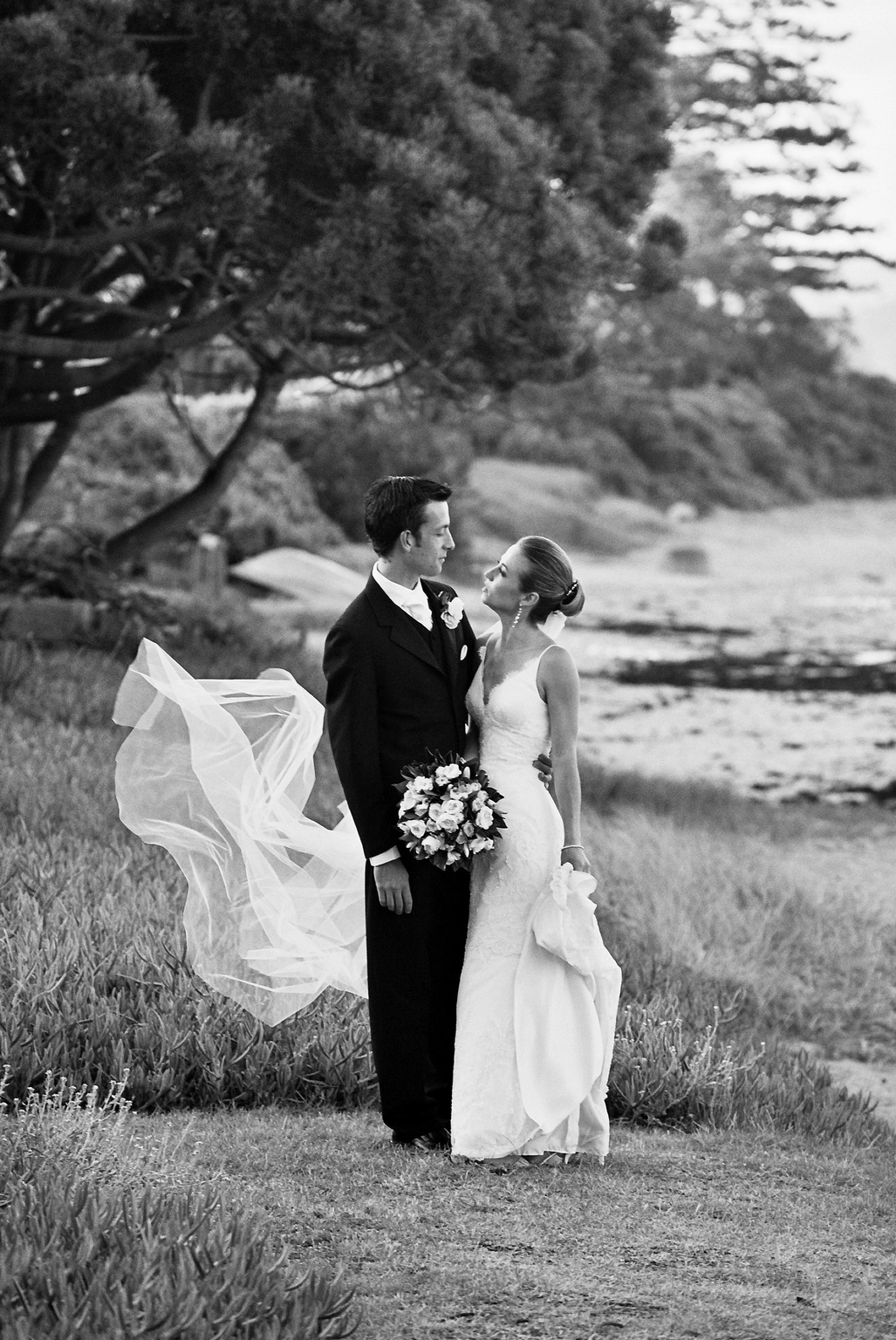 Sarhn - Bride and groom at the beach relax and talk while the wind blows photograph